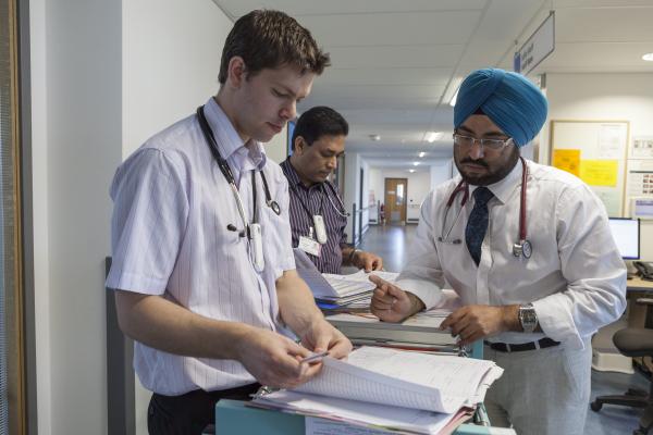 Meddygon yn trafod siart feddygol